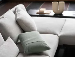 grey corner sofa with grey and green cushions